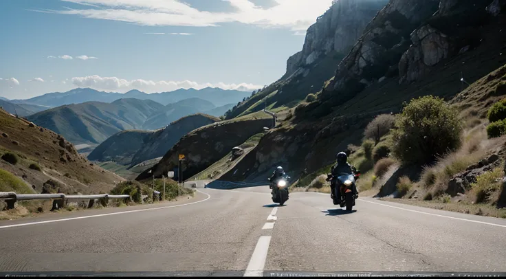 some motorcyclists descending a winding road between the mountains by the sea with their motorcycles. Clear day with sun.