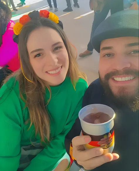 Smiling couple holding a cup of beer, white man, big chestnut beard, white woman, brown eyes, long straight hair