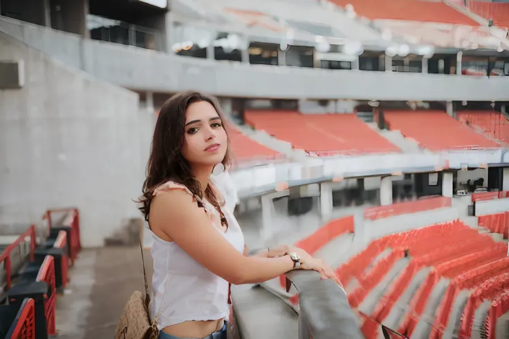 Woman standing in a stadium with a bag on her shoulder, standing in a stadium, Tiro em Sony A 7 III, inspired by Gina Pellón, standing in an arena, Alanis Guillen, Directed by: Briana Mora, Directed by: Emma Andijewska, photo shoot, Directed by: Andrée Rue...