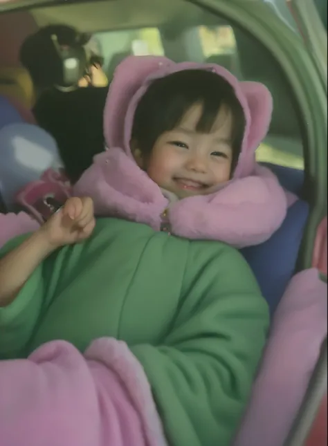 A baby is sitting in a car seat with a stuffed animal on it, 1 Infant、1 year old girl、Photo taken in 2002, A little smile, she is smiling and excited, Photographed in 2002, Im grabbing my dads fingers with my hand、Below her belly is a white blanket and a p...