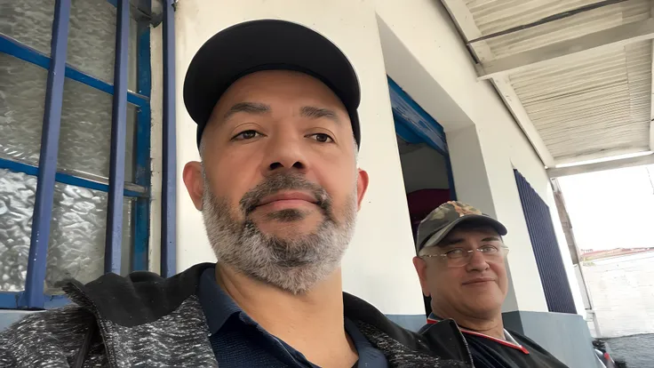 There are two men outside a building with a hat, david rios ferreira, andres rios, imagem de perfil, Foto realista, selfie de um homem, Directed by: Rodolfo Morales, victor maristane, taken in the early 2020s, gui guimaraes, Luis Nieves Sr., Fotografia sel...