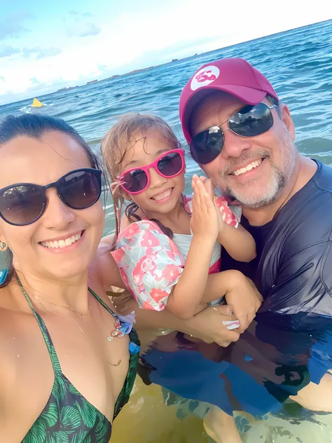 There are two adults and a child in the water with a man, on the ocean water, no oceano, divertindo-se, no oceano, vacation photo, no mar, in the water, na praia, in water! down to the shoulders, flutuando no oceano, na praia, Divirta-se, foto de praia, fa...