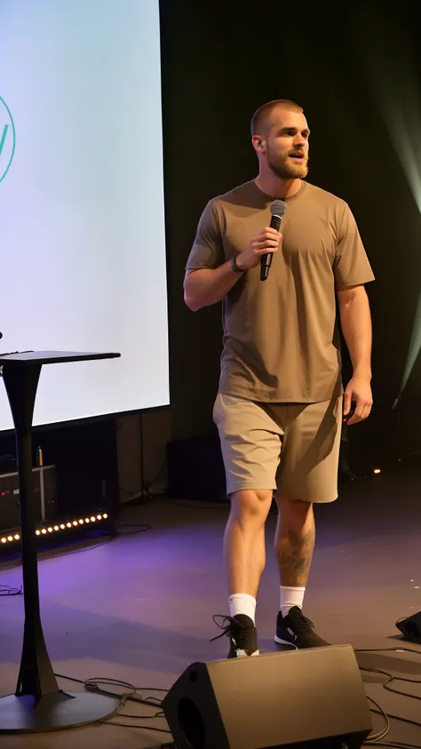 Theres a man standing on a stage with a microphone, no palco, comediante stand-up, no palco, em um palco, Apresentando-se no palco, Asmongold, Igreja de Ryan, taken in the early 2020s, adam varga, shorts cinza e meias pretas, rap no palco do festival, Tech...