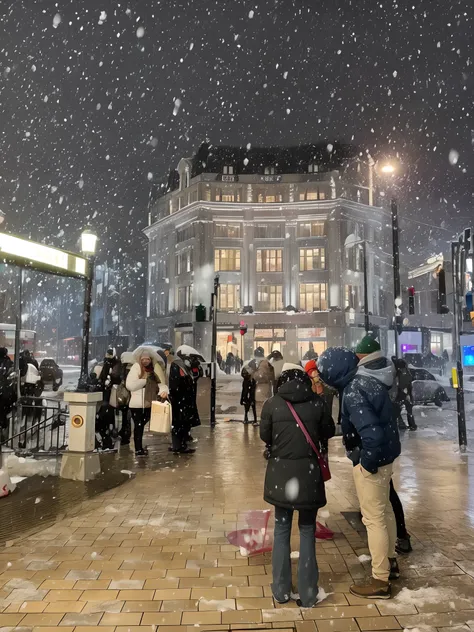 People stand on the sidewalks in the snow at night, It snows in the city，It snowed a lot, snowfall at night, snowing outside, snowing outside, stunning sight, Snow is falling, photograph taken in 2 0 2 0, Snowflakes fluttering, snow weather, snowy night, s...