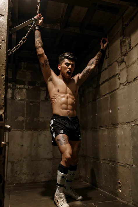 Zayn Malik screams while chained to the ceiling of a dungeon by his wrists wearing wet soccer kit