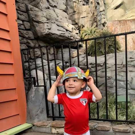 there is a small child who is standing in front of a fence, em um capacete viking, vestindo um uniforme viking, divertindo-se, Tempos medievais