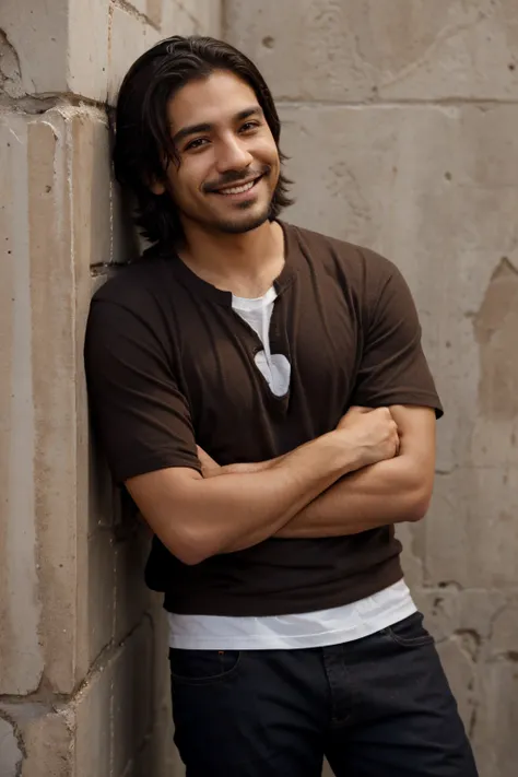 Short Mexican man around mid twenties with dark brown medium length hair and scruffy facial smiling 
leaning against a wall