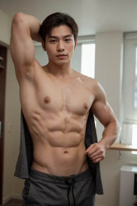 A muscular Korean model takes off his clothes.