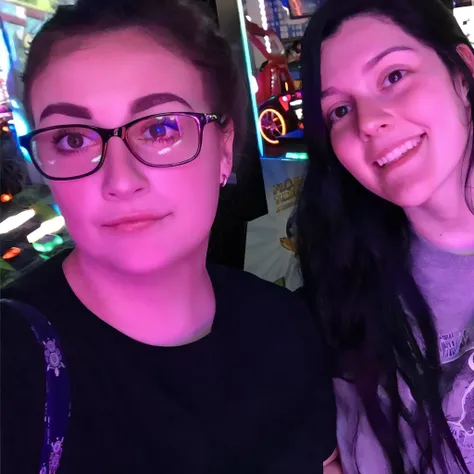 two women are posing for a picture in front of a game machine, charli bowater and artgeem, profile picture 1024px, profile pic, leslie david and lisa frank, taken in the early 2020s, vacation photo, both smiling for the camera, snapchat photo, alex yanes a...