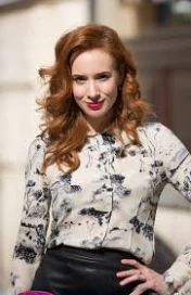 there is a woman that is standing in the street with her hands on her hips, eleanor tomlinson, with curly red hair, hr ginger, red haired young woman, playful smirk, with red hair, a redheaded young woman, leaked image, inspired by Julia Pishtar, redhead w...