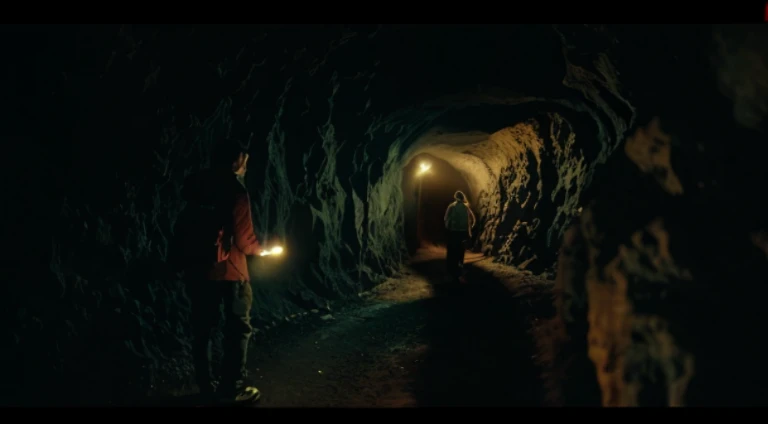 Two people walking in a dark tunnel with lights on, movie still dnd, In a cave. underexposed, movie stilldnd movie, Still from live-action movies, screenshots from movies, stills from movies, Still in the movie, Movies are still in 8k, Still from the movie...