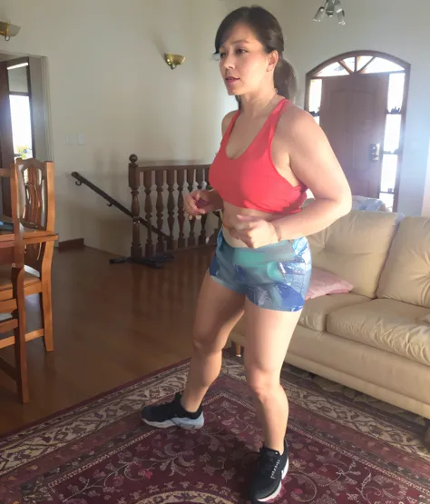 there is a woman in a red blouse and blue shorts playing video games, side view of her taking steps, malhar, 4 5 I, ela tem cerca de 7 0 anos, metade feito, 5 5 I, suando intensamente, ela tem cerca de 6 0 anos, suando muito, muito suado, ela tem cerca de ...