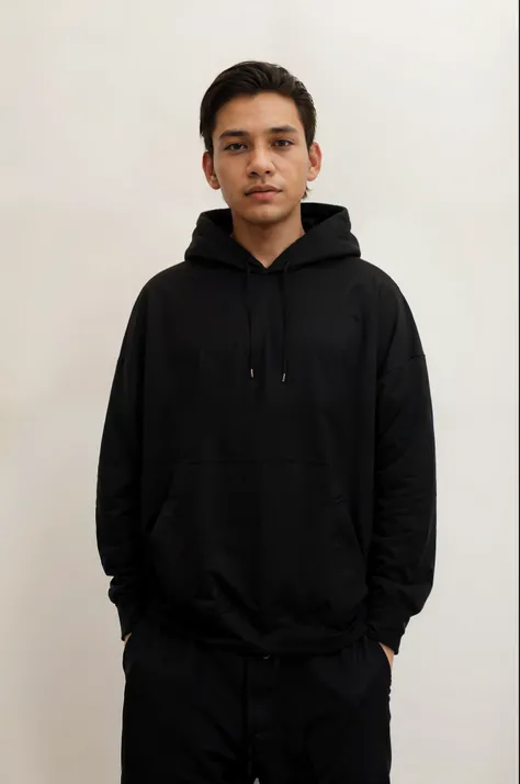 a man in a black hoodie standing against a white wall, wearing a black hoodie, wearing an oversized hoodie, dressed black hoodie, black hoodie, in a black hoodie, black hoodie techie, wearing hoodie, wearing jeans and a black hoodie, oversized hoodie, wear...