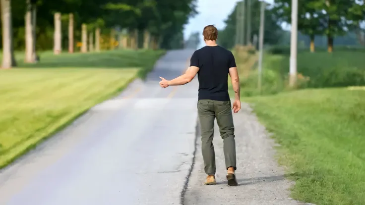 there is a man that is walking down the road with a skateboard, standing in road, walking away from camera, walking away, standi...