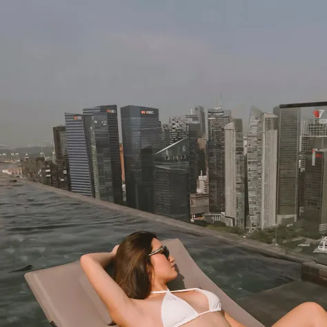 woman in white bikini laying on a lounger overlooking a city, on rooftop, in a rooftop, in a luxurious pool, on a rooftop, sits on a rooftop, chill time. good view, next to a pool, sexy :8, sitting on a skyscraper rooftop, gemma chen, set on singaporean ae...