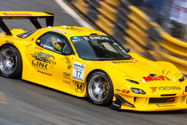 yellow sports car driving on a race track with a yellow barrier, motorsports photography, motor sport photography, masashi kishimoto, kentaro miura style, macoto takahashi, gtr xu1, miura kentaro, panning shot, high speed action, yusuke nakano, japanese dr...