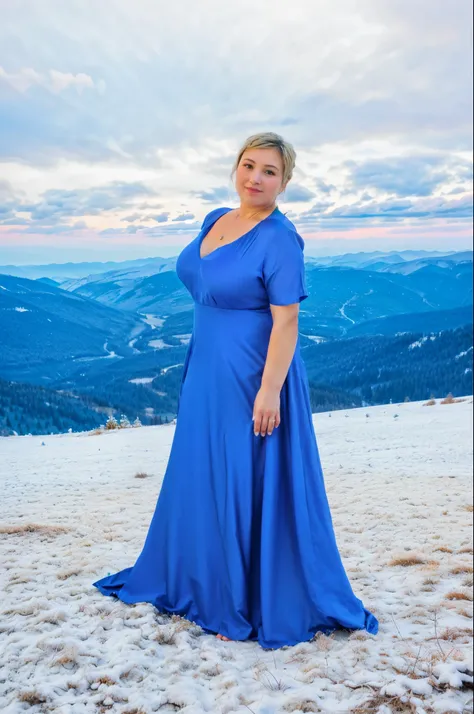 A woman in a blue dress stands in the winter mountains, gentle sunset