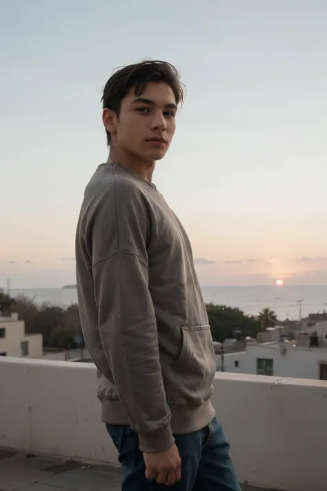 un hombre latino. short hair with sweatshirt 24 years old looking towards the sunset