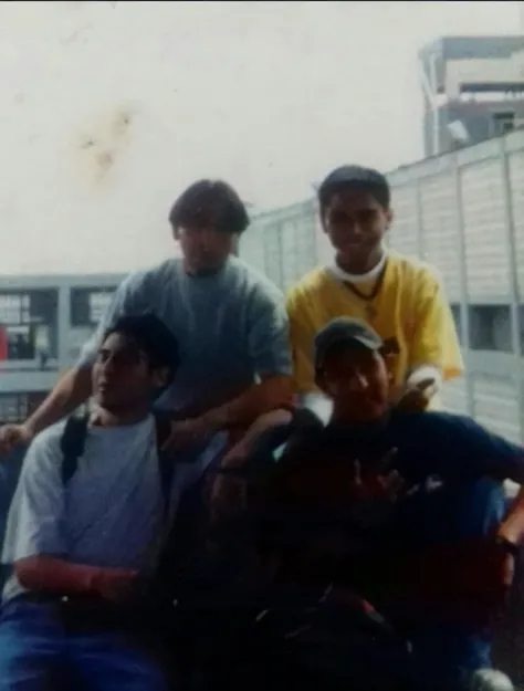 Hay cuatro hombres sentados juntos en un banco en la ciudad., foto en color de los 90, taken in the early 1990s, foto de los 90, foto de los 90, 19foto de los 90, tomado en 1 9 9 7, viejo cuadro, foto 1 9 9 0 s, granoso photo, Disposable camera photo, gran...