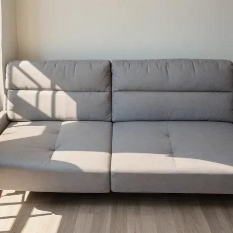 gray couch against a white wall. No windows on wall. sunlight coming from left side illuminating the couch. Couch is up close to viewer