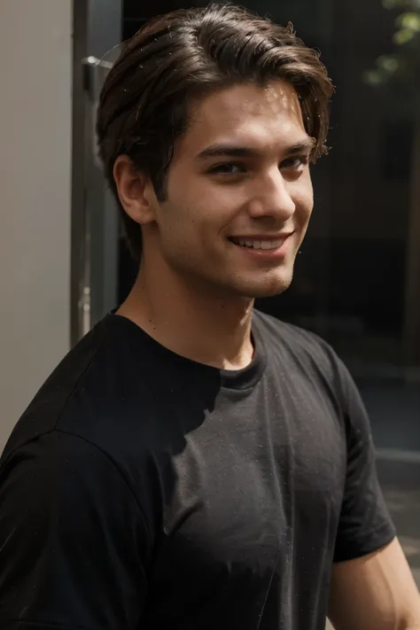 A close-up of a young attractive man in a black t-shirt, who smiles to the side.