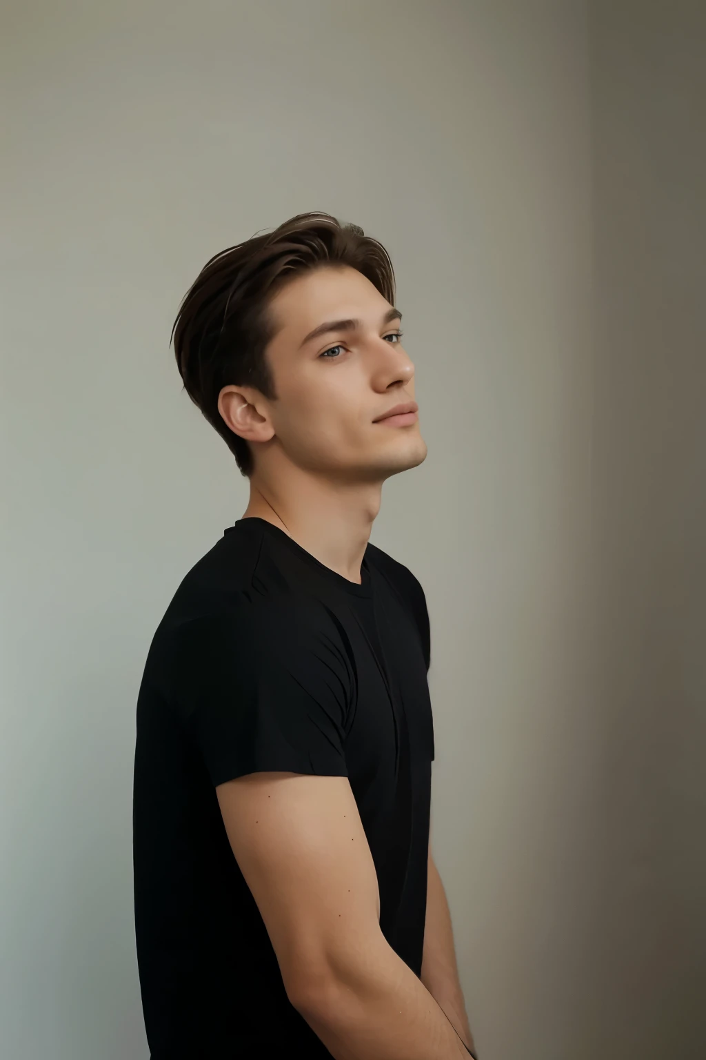 a 23 year old man, wearing a black t-shirt, in a white room, he seems to be having fun, this is for a profile photo