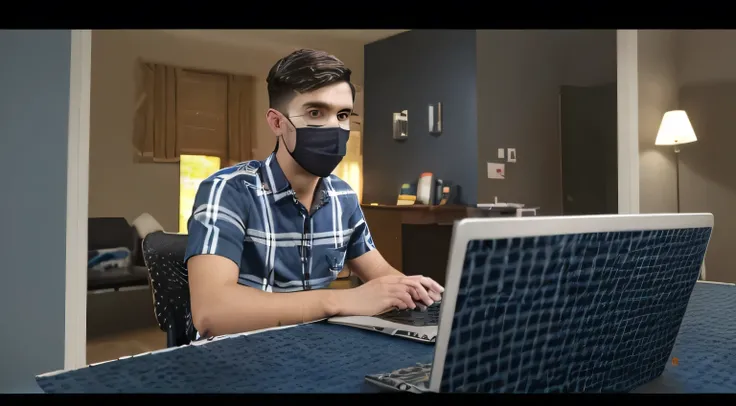 image shows a young man sitting at a desk with a laptop in front of him. He is wearing a blue and white checkered shirt. He has dark hair  .The background appears to be a room with a window and a door. The man is looking at the camera to make a YouTube vid...