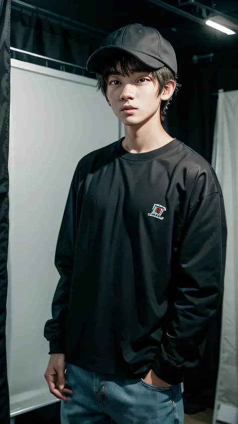 a young man wearing a cap and a long-sleeved shirt inside a photography studio showing his entire body