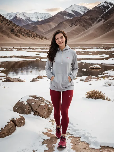 a twenty one year old young woman with dark brown hair, wearing leggings and running shoes, standing on snow-covered rocks in the desert mountains with dark red , smiling at the camera, posted to Snapchat in the winter of 2018