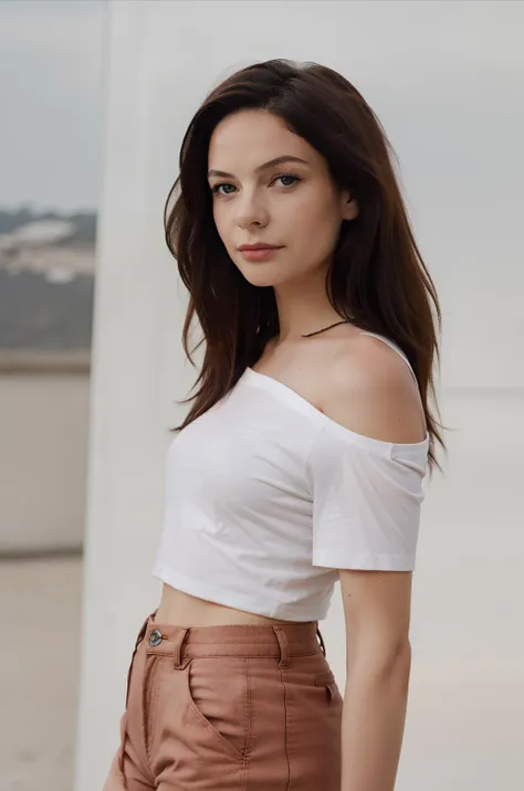 a woman in a white shirt and brown pants posing for a picture